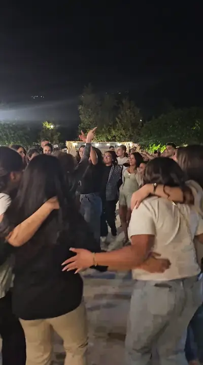 Friends hugging on the dance floor at night
