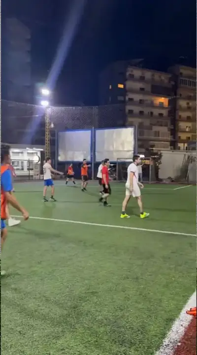 A player running with the ball on an artificial pitch