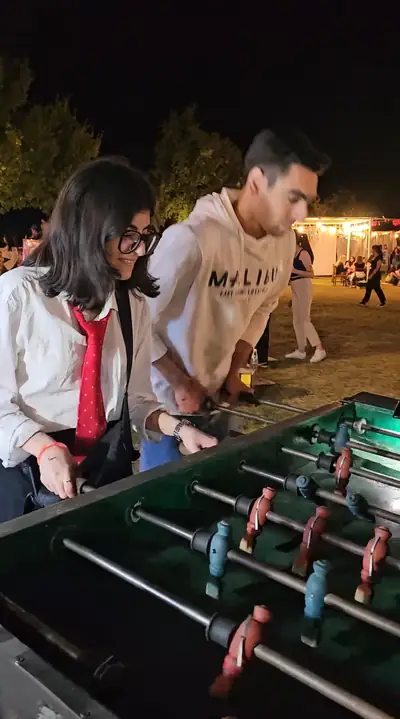 Two guests playing foosball at night