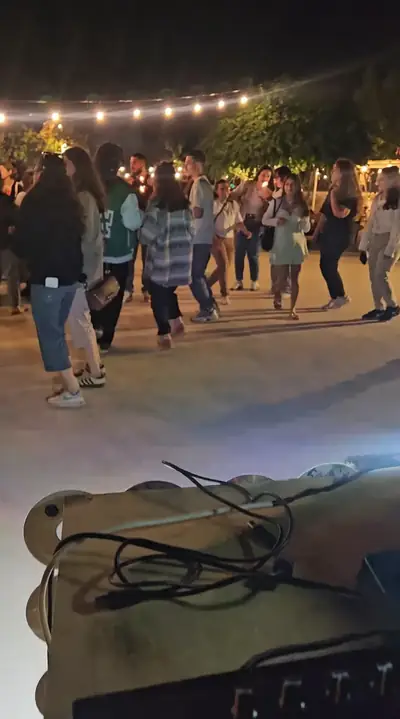 A crowd under string lights