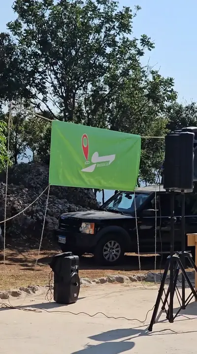 The outdoor stage with a green banner and speakers