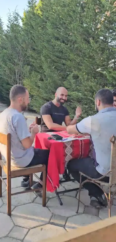 Friends playing cards at a table outdoors