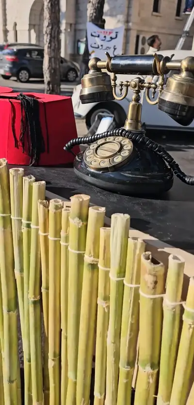 Old rotary telephones and a red fez on a table