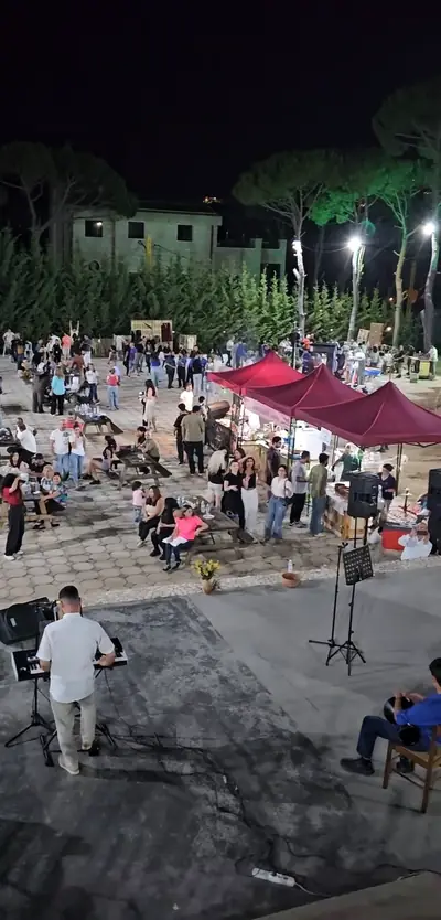 The square full of people under tents at night