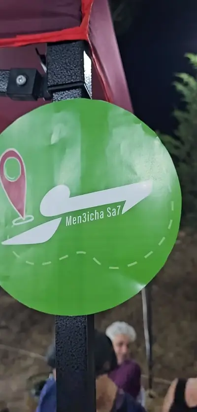 The green Sawa Men 3icha Sa7 sign