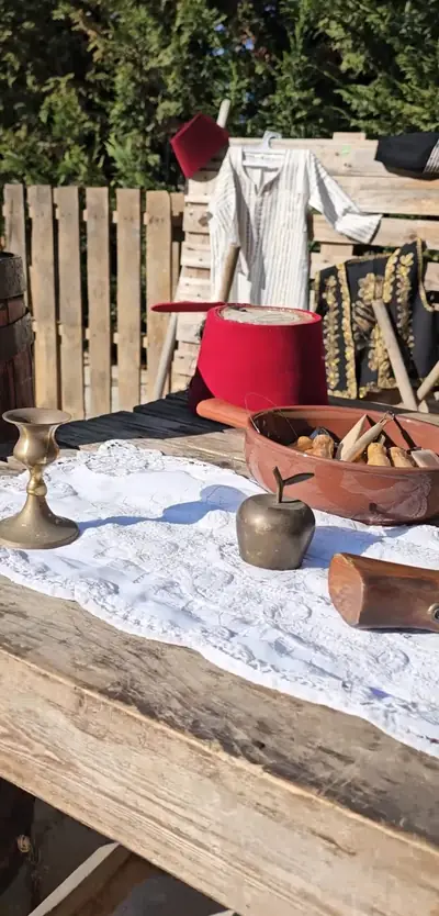 A table set with a fez, copper pots and lace