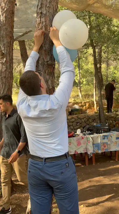 A volunteer tying balloons to a tree