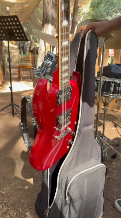 A red electric guitar on a stand
