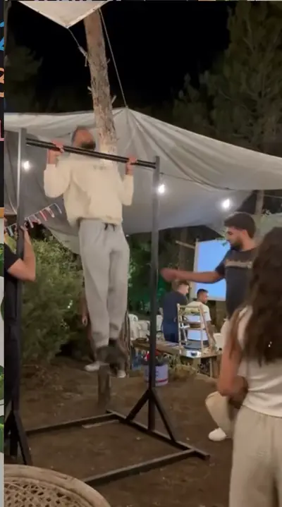 A guest doing a pull-up on a bar under the canopy at night