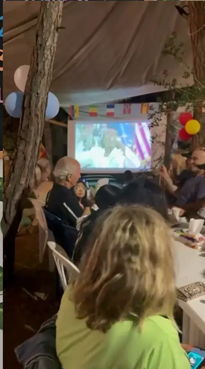 Guests at tables under the canopy watching the final