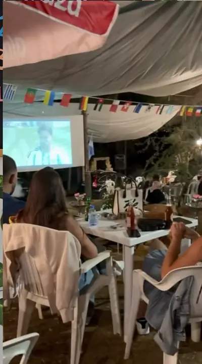 Guests at long tables facing the screen
